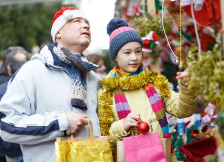 Father with daughter selecting Christmas decorationの写真素材