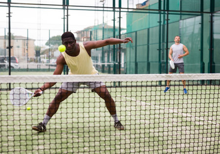 Two man playing together paddle tennis
