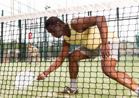 Sporty emotional man playing doubles padel gameの写真素材
