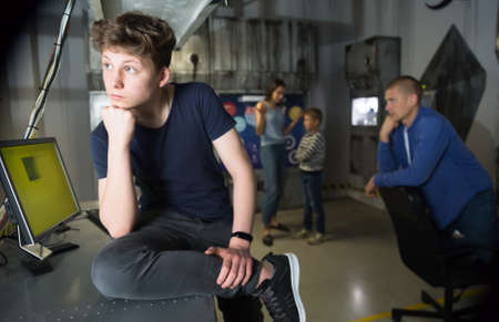 Pensive teenager solving conundrum with family in quest roomの写真素材