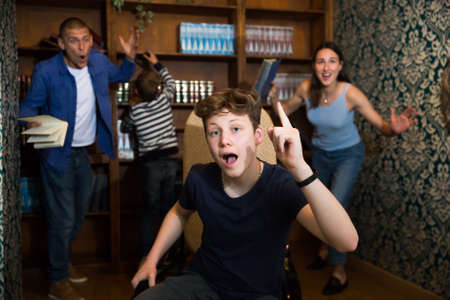 Emotional teenager having idea in solving puzzle in quest roomの写真素材