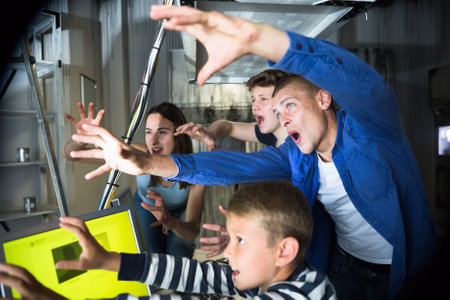 Friendly family has fun in the quest room, stylized as a laboratoryの写真素材