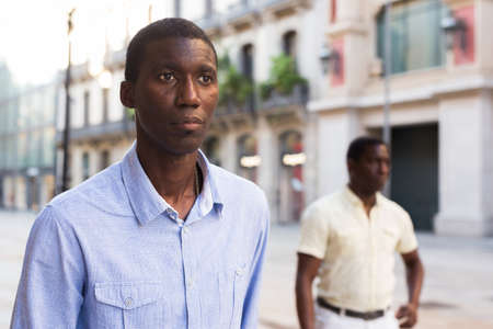 Handsome african american man walking along streetの写真素材