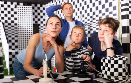 Brooding family trying to find a solution to a puzzle in the quest roomの写真素材