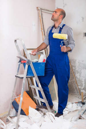 Professional constructor is standing with roller in uniformの写真素材