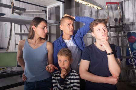 Interested family contemplating solving conundrums in escape roomの写真素材
