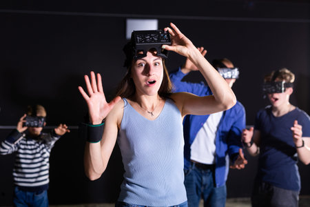 Astonished woman in VR headset playing virtual reality games