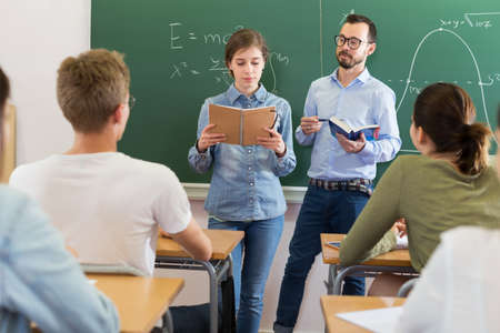 Girl answering near blackboardの写真素材