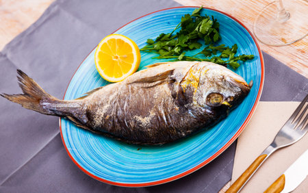 Baked dorado fish with orange and parsley