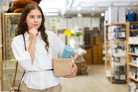 Woman buyer standing in shopping room with decor for homeの写真素材