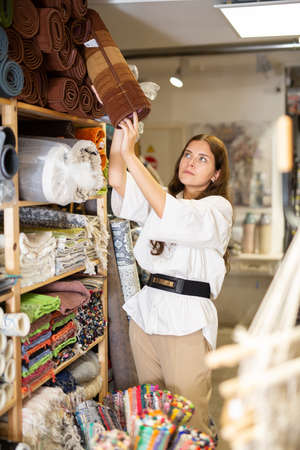 Female shopper chooses floor mat in storeの写真素材