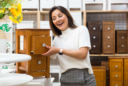 Portrait of woman choosing dressing table in storeの写真素材
