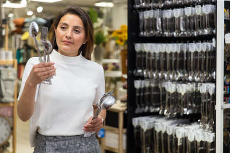 Woman chooses flatware in the shopの写真素材