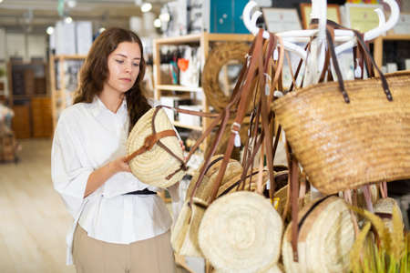 Woman buying straw bag at hardware storeの写真素材
