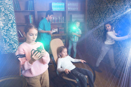 Group of friends trying to find solution of quest in escape room with antique furnituresの写真素材