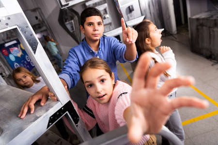 Girl and boy trying to solve puzzles to get out of escape room; reaching for keyの写真素材