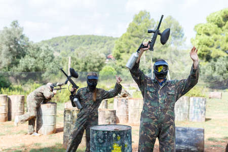 Paintball player standing raised armsの写真素材