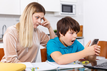 Woman scolding boy at kitchenの写真素材