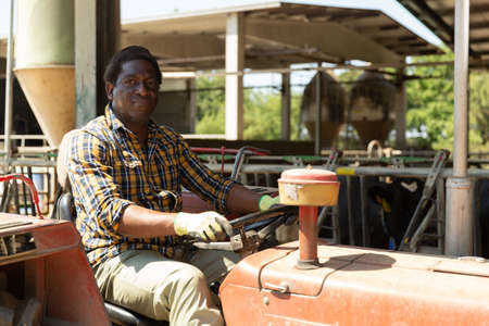 Afro american farmer sitting in a tractorの写真素材