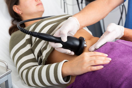 Woman getting radiofrequency lifting procedure on abdomen