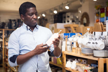 African American choosing condiment dispenser in home furnishings storeの写真素材