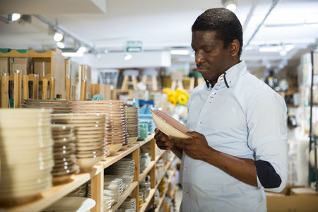 Man choosing new crockery in dinnerware storeの写真素材