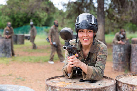 Portrait of asian female with gun on paintball fieldの写真素材