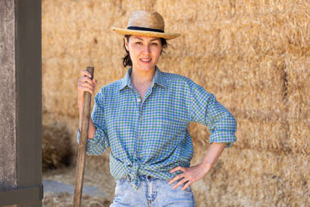 Woman posing at hay storage on farmの写真素材