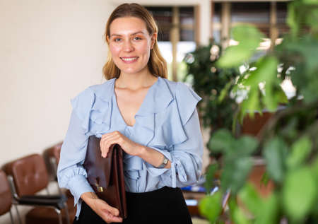 Positive businesswoman with briefcase for documentsの写真素材