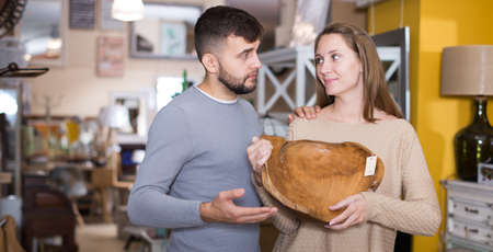 Couple with stylish wooden dish in shopの写真素材