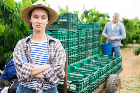 Portrait of a focused farmer woman standing in a fruit nurseryの写真素材