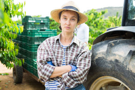 Female gardener with crossed hands posing at gardenの写真素材