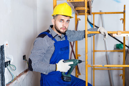 Male worker is ready to work with a dril