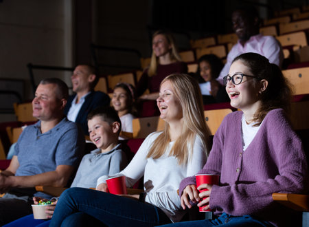Cheerful parents with tween children watching comedy in cinemaの写真素材