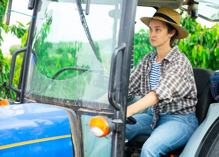 Middle age female working on a tractor at orchard