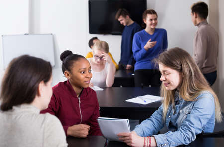 joyous classmates having animated talks at break between classesの写真素材