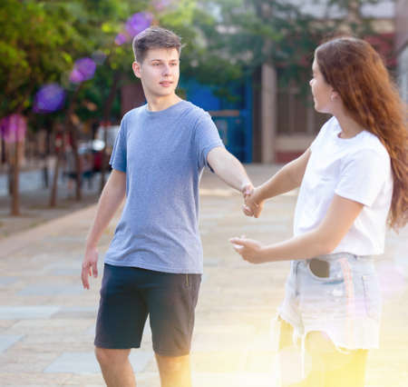 Two youngsters are walking hand in handの写真素材