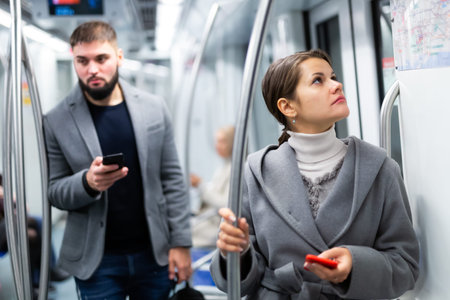 Woman with smartphone in subway car
