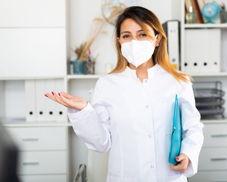 Colombian female medical mask in uniform holding clipboard