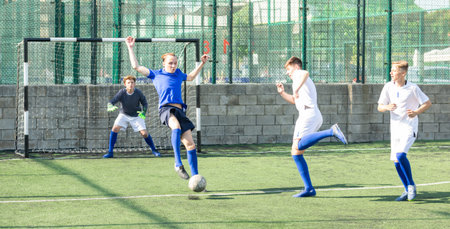 Teens playing soccer football match. Competition between two youth soccer teams