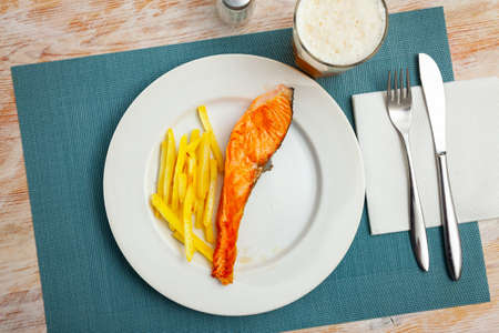 Deliciously steak of baked salmon with french friesの写真素材