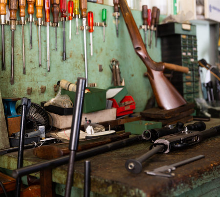 Disassembled automatic rifle on the table of weapons workshop