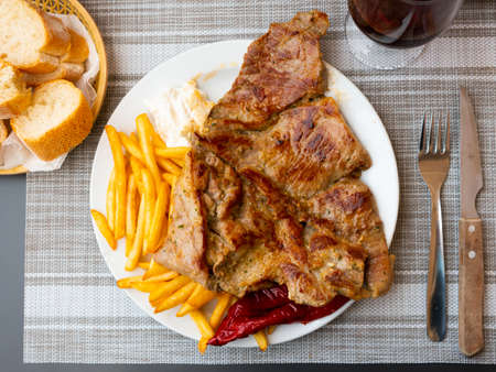 Grilled pork with potato, pepper and sauceの写真素材