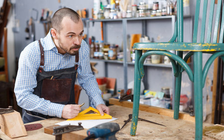 Carpenter measuring wooden plankの写真素材