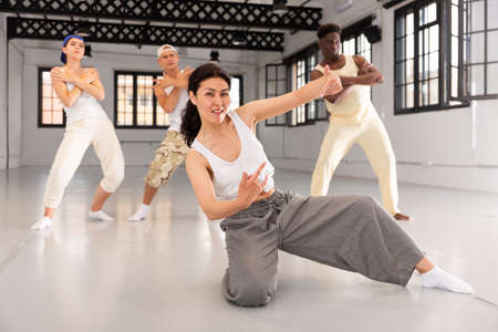 People in casual clothes training hip-hop in class, posing and having funの写真素材