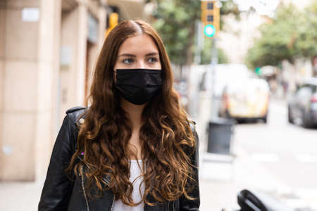 Young woman in protective face mask on a streetの写真素材