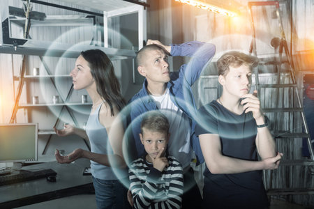 Family solving conundrums in quest room stylized as bunkerの写真素材