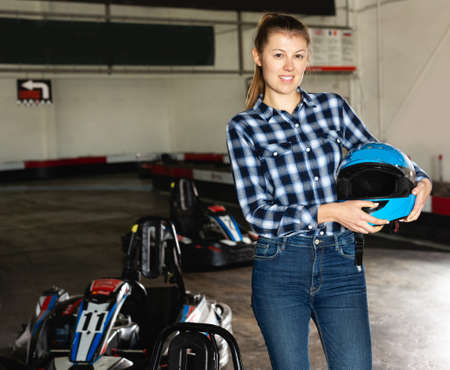 girl posing with helmet in her hands at kart circuitの写真素材