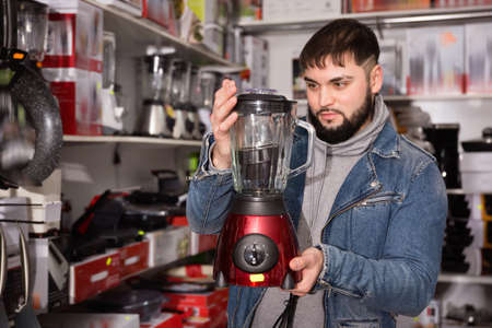 Adult male is standing with new mixer for his home in the storeの写真素材