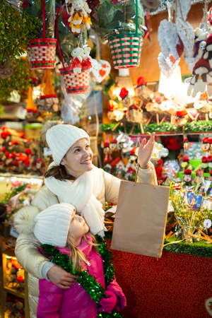 Glad mother with little daughter buying decorations for Xmasの写真素材